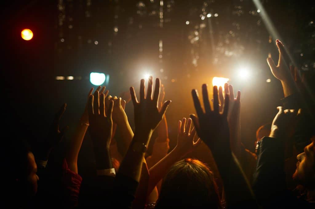 People waving hands at concert